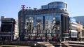 Reflections of city center in glass windows of modern big Telekom building in Skopje on sunny summer day Royalty Free Stock Photo