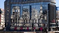 Reflections of city center in glass windows of modern big Telekom building in Skopje on sunny summer day