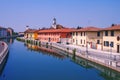 REFLECTIONS OF COLORFUL BUILDINGS ON THE WATER OF THE RIVER NAVIGLIO IN GAGGIANO VILLAGE IN ITALY