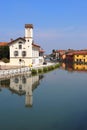 REFLECTIONS OF COLORFUL BUILDINGS ON THE WATER OF THE RIVER NAVIGLIO IN GAGGIANO VILLAGE IN ITALY