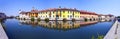 REFLECTIONS OF COLORFUL BUILDINGS ON THE WATER OF THE RIVER NAVIGLIO IN GAGGIANO VILLAGE IN ITALY