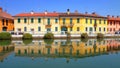 REFLECTIONS OF COLORFUL BUILDINGS ON THE WATER OF THE RIVER NAVIGLIO IN GAGGIANO VILLAGE IN ITALY