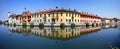 REFLECTIONS OF COLORFUL BUILDINGS ON THE WATER OF THE RIVER NAVIGLIO IN GAGGIANO VILLAGE IN ITALY