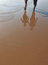 Reflections of a couple walking on the beach Costa Ballena, Rota, Cadiz province, Spain Royalty Free Stock Photo