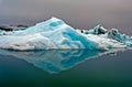 Reflections of crystal blue and white icerbergs in black dark smooth glassy water in dim gloomy light - Jokulsarlon Glacier Lagoon Royalty Free Stock Photo