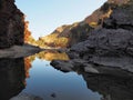 Reflections in the dark waters of Ormiston Gorge with red glowing cliffs Royalty Free Stock Photo