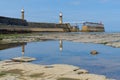 Reflections of East and West lighthouses in tidal pool. Whitby. North Yorkshire.