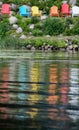 reflections of empty colorful lawn furniture chairs along the lakeshore in summer