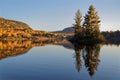 Reflections of two firs of a small island at sunset Royalty Free Stock Photo