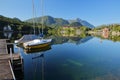 Reflections on Grundlsee lake with mooring boats and Zinken mountain in the background