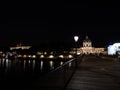 Reflections of lights on the river at bridge of Arts at night, Paris.