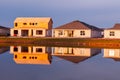 Reflections of new houses, being built on shoreline of a lake Royalty Free Stock Photo