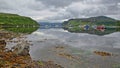 Reflections of the Portree Bay with a colorful seashore in the foreground and Ben Tianavaig mountain in the background, Isle of Sk Royalty Free Stock Photo