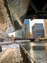 Reflections of snow covered Chicago Loop along the riverwalk of the Chicago River underneath a bridge in the Loop. Royalty Free Stock Photo