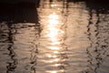 Reflections of sun and masts of a sailing vessel on the waterr Royalty Free Stock Photo