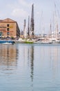 Reflections in the water of buildings and harbor cranes of Porto Antico in Genoa, Liguria, Italy, Europa.