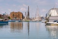 Reflections in the water of buildings and harbor cranes of Porto Antico in Genoa, Liguria, Italy, Europa.