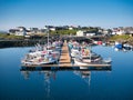 With reflections in the water, local fishing and leisure boats moored at Hamnavoe Marina in Shetland, Scotland, UK