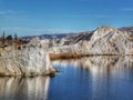 Reflections of the white sandstone cliffs in the waters of the Blue Lake at St Bathans in New Zealand