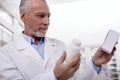 Reflective male pharmacist verifying drugs