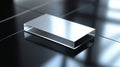 Reflective rectangular metal object on a glossy black surface under soft light conditions Royalty Free Stock Photo