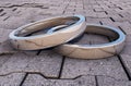2 Reflective Silver Rings on a pavement.