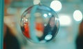 Reflective sphere hangs, blurring bustling indoor scene person reflected for holidaydecor themes Royalty Free Stock Photo