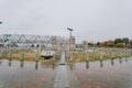 Reflective stone path leading through a modern open air monument park under a grey sky Royalty Free Stock Photo
