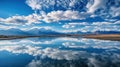 Reflective Tranquility: A Captivating Mirror-Like Lake Reflecting Distant Snow-Capped Mountains and Serene Clouds