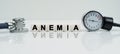 On a reflective white surface lies a stethoscope and cubes with the inscription - ANEMIA