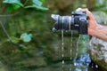 man pulls his reflex camera out of the river flooded with water Royalty Free Stock Photo