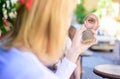 Reflexion girl looking in mirror check her appearance. Check if everything is right. Woman looking in her pocket mirror Royalty Free Stock Photo