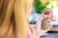 Reflexion girl looking in mirror check her appearance. Woman looking in her pocket mirror selective focus defocused