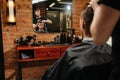 Reflexion of a hairdresser making a haircut for a young man in a barber shop Royalty Free Stock Photo