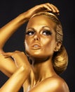 Reflexion. Portrait of Glossy Woman with Bright Golden Makeup. Bronze Bodypaint