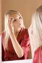 Reflexion of young blone woman removing make-up Royalty Free Stock Photo