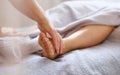 Reflexologist applying pressure to foot with thumbs. Royalty Free Stock Photo