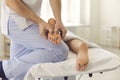 Professional male masseur doing foot massage for young woman in modern health center