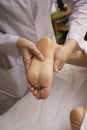 Reflexology foot massage, spa foot treatment. exotic feet therapy in spa, vertical Royalty Free Stock Photo