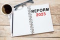 REFORM 2023 Text on notebook in office desk workplace