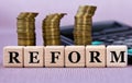 REFORM - word on wooden cubes on the background of coins and calculator Royalty Free Stock Photo