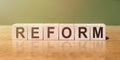 Reform word in Wooden cubes on a green-brown background Royalty Free Stock Photo