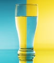 Refraction of light by a glass on a blue and yellow squared background. Abstract glass art