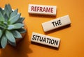 Reframe the situation symbol. Concept words Reframe the situation on wooden blocks. Beautiful orange background with succulent Royalty Free Stock Photo