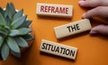 Reframe the situation symbol. Concept words Reframe the situation on wooden blocks. Beautiful orange background with succulent Royalty Free Stock Photo