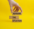 Reframe the situation symbol. Concept words Reframe the situation on wooden blocks. Beautiful yellow background. Businessman hand Royalty Free Stock Photo