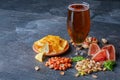 Refreshing alcoholic beverage. Dark ale in a glass. Composition of snacks. Beer and appetizers on a table background Royalty Free Stock Photo