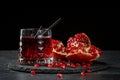 Refreshing alcoholic cocktails. Composition of a glass of red drink and a ripe garnet on a black background. Fruity red Royalty Free Stock Photo