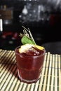 Refreshing alcoholic drink with berries, ice vodka and gin, lemon peel served in glass cup on the counter on black background Royalty Free Stock Photo