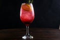 refreshing alcoholic drink with berries, ice vodka and gin, lemon peel served in glass cup on the counter on blurred background Royalty Free Stock Photo